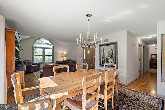 dining area featuring light hardwood / wood-style flooring and a notable chandelier