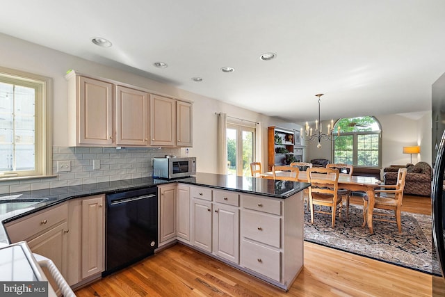 kitchen with pendant lighting, black dishwasher, tasteful backsplash, kitchen peninsula, and a chandelier