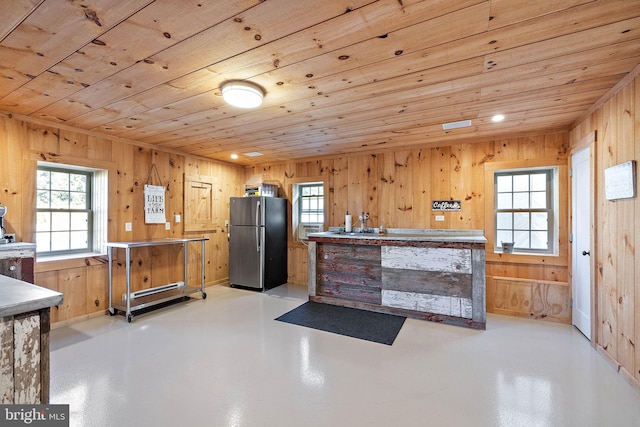 kitchen with stainless steel fridge, wooden walls, and wooden ceiling