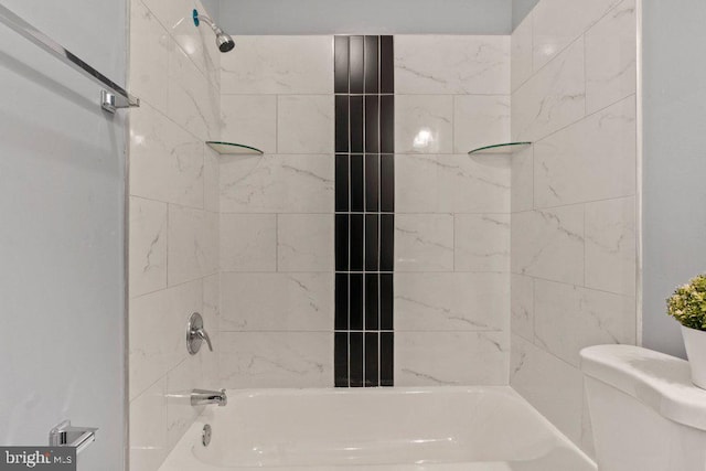 bathroom featuring tiled shower / bath and toilet