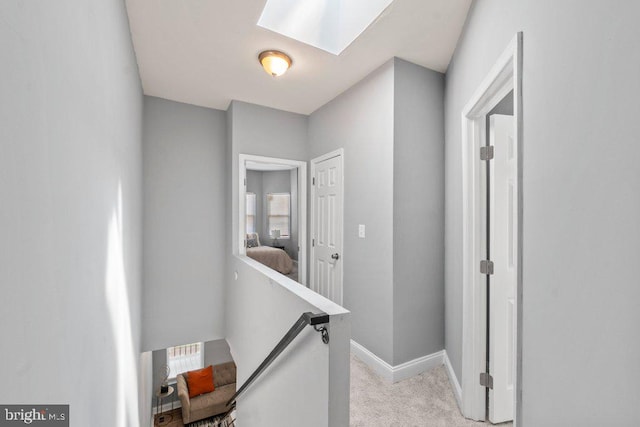 corridor featuring light carpet and a skylight