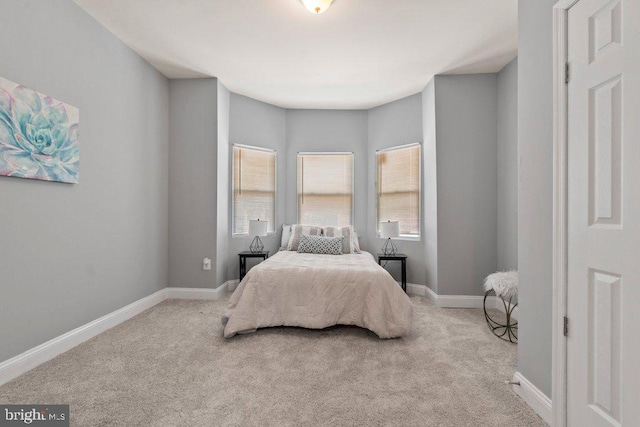 bedroom featuring light carpet and multiple windows