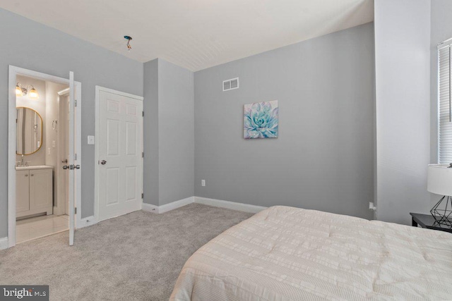 carpeted bedroom featuring connected bathroom and sink