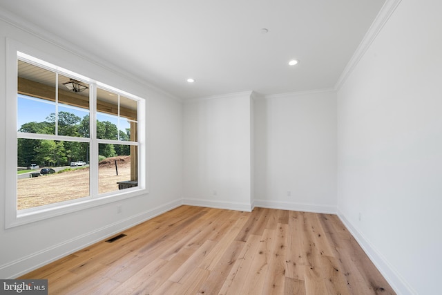 empty room featuring light hardwood / wood-style floors and ornamental molding