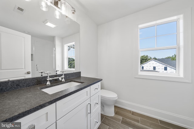 bathroom featuring vanity, an enclosed shower, and toilet