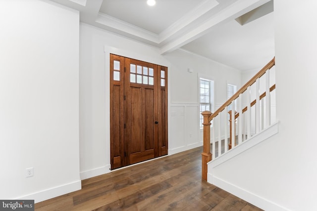 foyer entrance with a wainscoted wall, stairway, dark wood-style flooring, crown molding, and a decorative wall