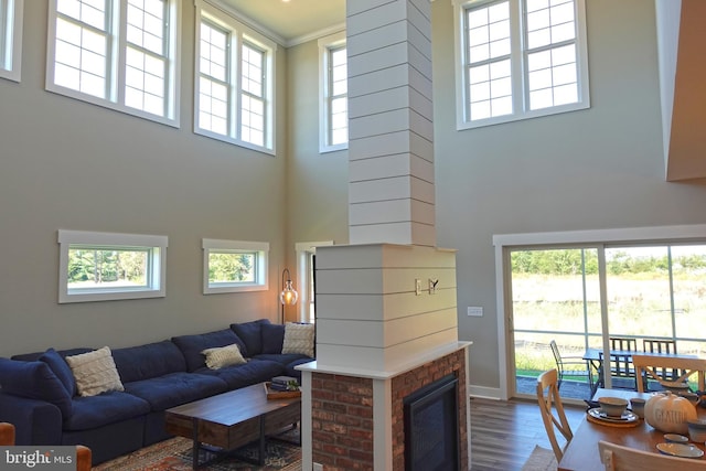 living room featuring a towering ceiling, hardwood / wood-style flooring, and ornate columns