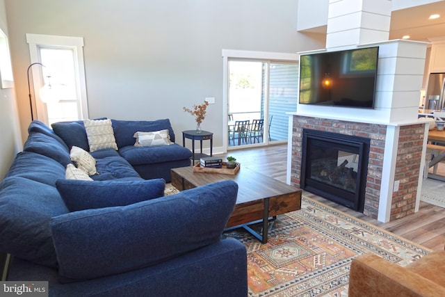 living room featuring wood-type flooring and a brick fireplace