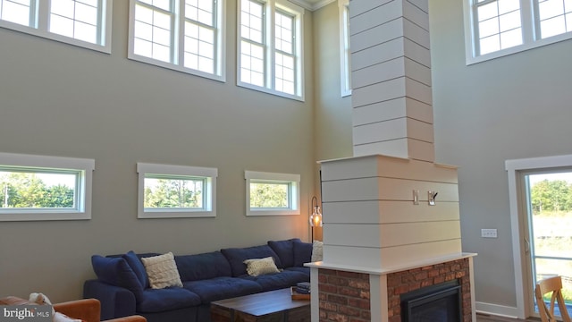 living room with a towering ceiling and a brick fireplace