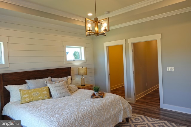 bedroom featuring a chandelier, dark wood-type flooring, and ornamental molding