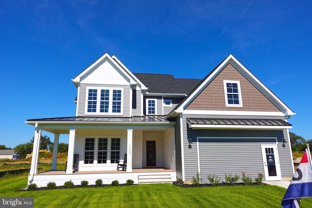 rear view of house with a porch and a yard