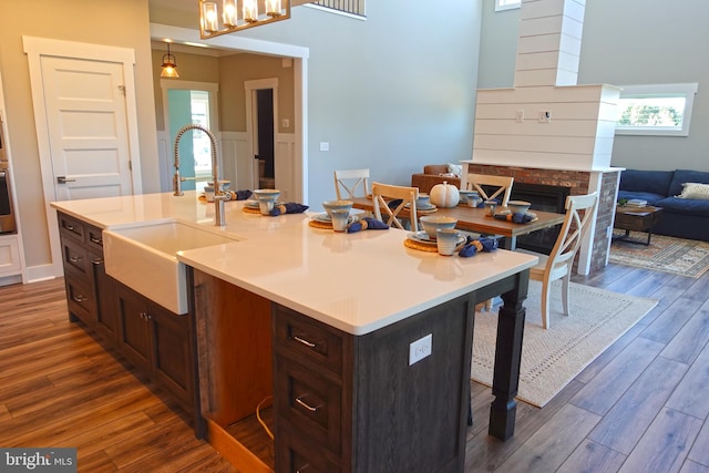 kitchen with a kitchen breakfast bar, a center island with sink, hanging light fixtures, and sink