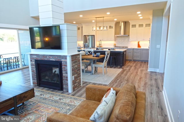 living room featuring a fireplace, light hardwood / wood-style floors, and sink