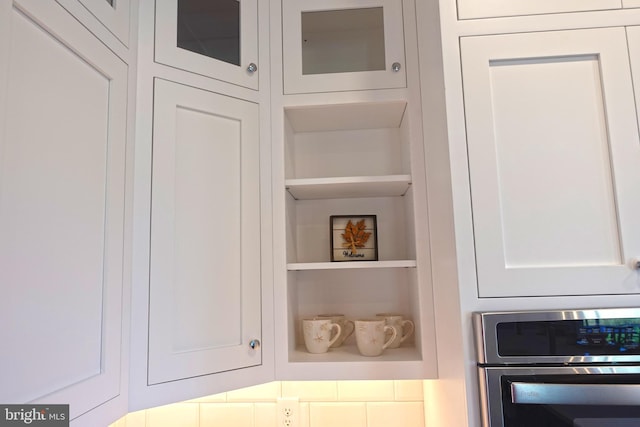 room details with white cabinets, stainless steel oven, and built in features