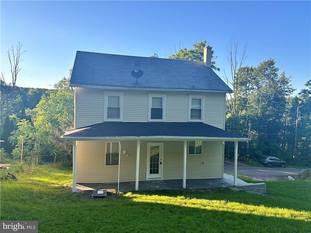 rear view of property with a yard