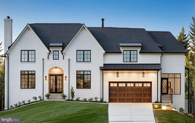 modern farmhouse with a garage, a front yard, and french doors