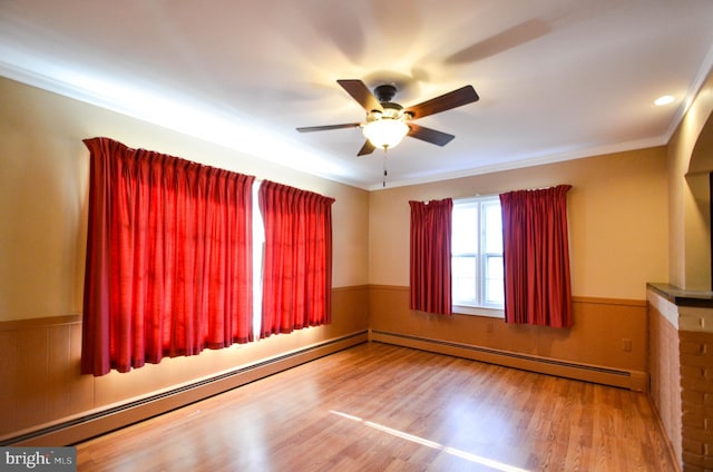 spare room with hardwood / wood-style flooring, ceiling fan, ornamental molding, and a baseboard radiator