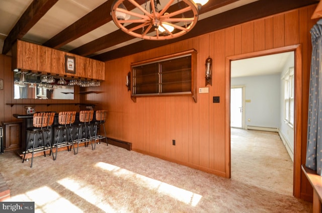 bar featuring beam ceiling, light colored carpet, wooden walls, and a baseboard radiator