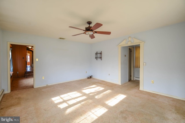 empty room featuring ceiling fan, light colored carpet, and baseboard heating