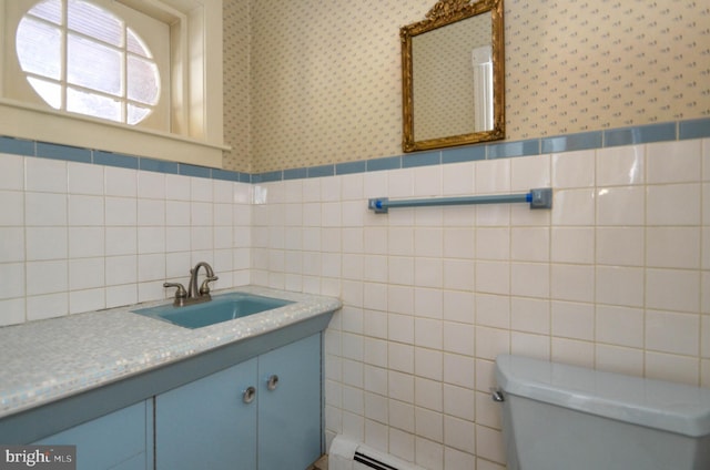 bathroom featuring baseboard heating, vanity, tile walls, and toilet