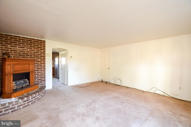 unfurnished living room with light carpet and a fireplace