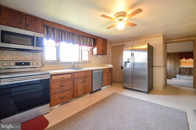 kitchen featuring light carpet, stainless steel appliances, ceiling fan, sink, and a baseboard radiator