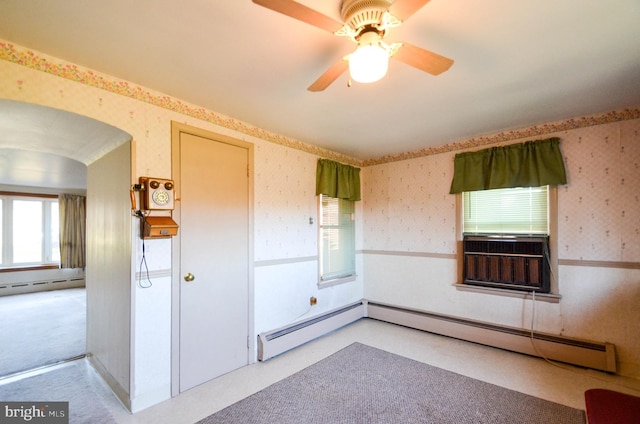 unfurnished room featuring ceiling fan and a baseboard radiator