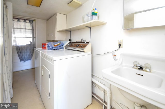 laundry area featuring washing machine and clothes dryer and sink