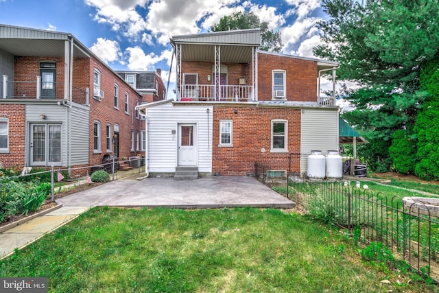 back of house featuring a lawn and a patio