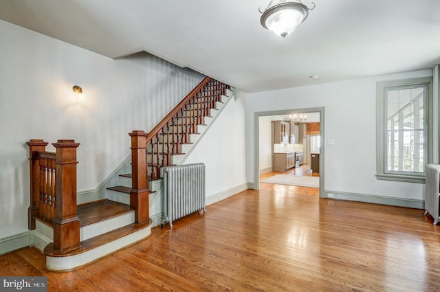 interior space featuring radiator, a chandelier, and light hardwood / wood-style floors