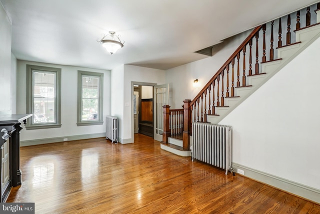 foyer entrance featuring radiator and hardwood / wood-style floors