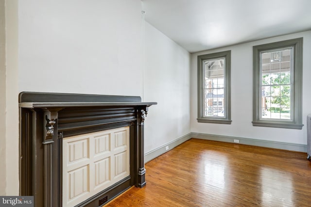 unfurnished living room with radiator and wood-type flooring