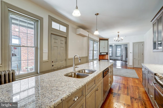 kitchen featuring light stone counters, sink, pendant lighting, and a wall mounted air conditioner