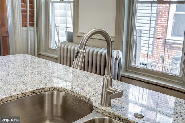 details featuring light stone counters and radiator heating unit