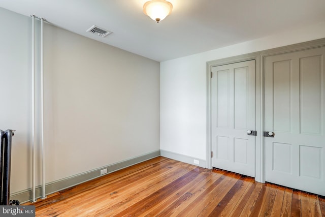 unfurnished bedroom with a closet and wood-type flooring