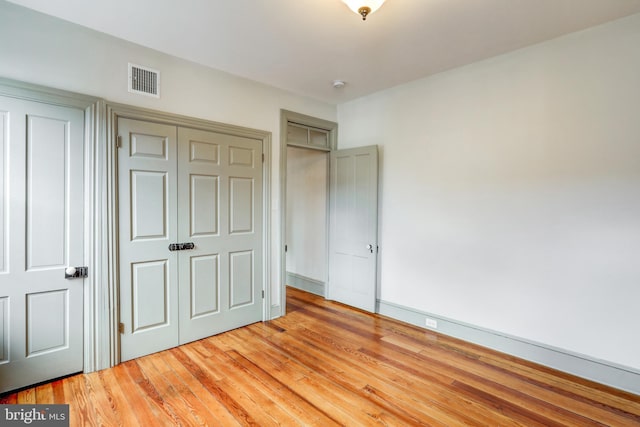 unfurnished bedroom with light hardwood / wood-style floors and a closet