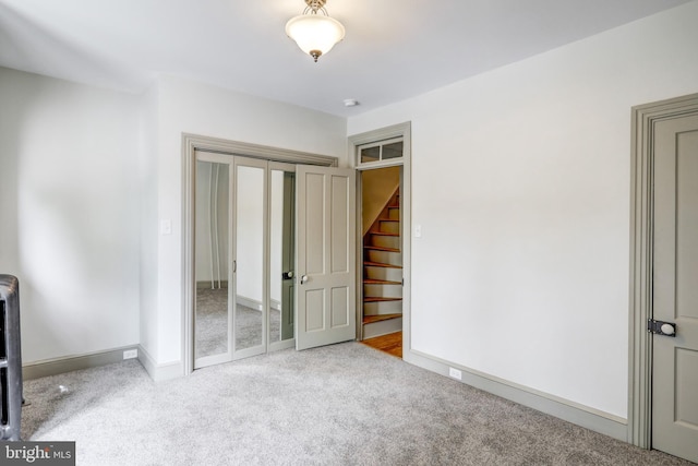 unfurnished bedroom featuring a closet and light colored carpet