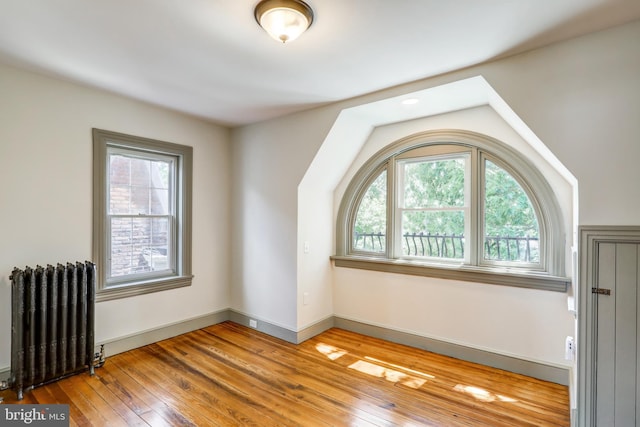 additional living space with light wood-type flooring and radiator