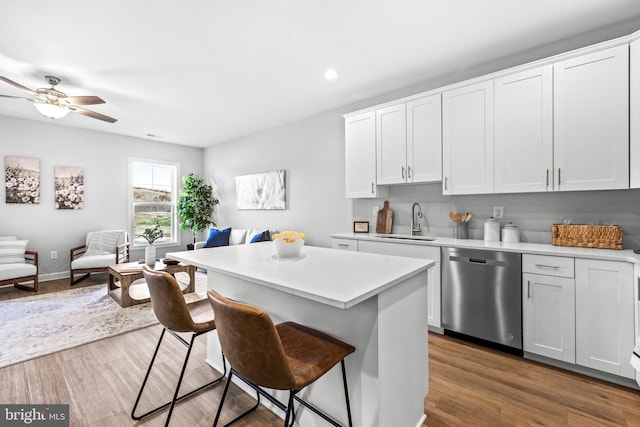 kitchen featuring white cabinets, dishwasher, a center island, sink, and ceiling fan