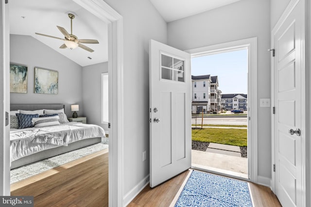 bedroom with light hardwood / wood-style flooring, ceiling fan, vaulted ceiling, and access to exterior