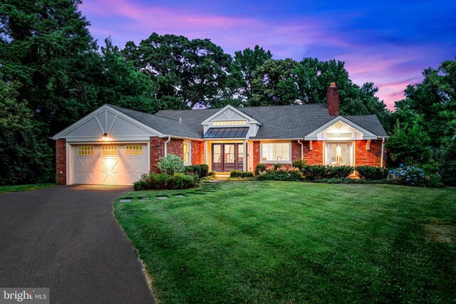 view of front of property featuring a garage and a lawn