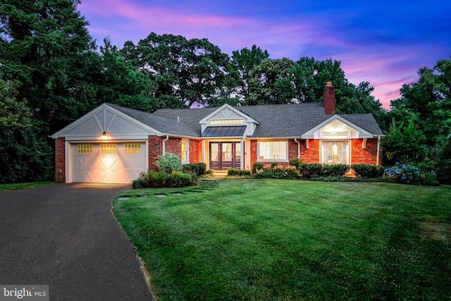 ranch-style home with a garage and a lawn