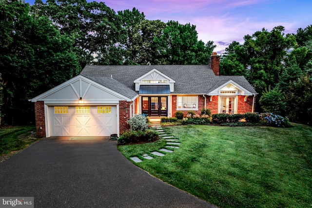 view of front of property featuring a garage and a yard