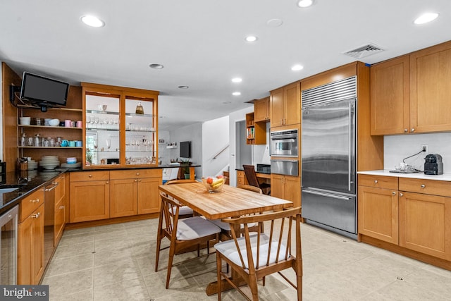 kitchen featuring light tile patterned flooring, stainless steel appliances, dark stone counters, and beverage cooler