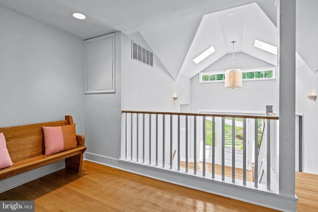 sitting room featuring light hardwood / wood-style floors and lofted ceiling with skylight