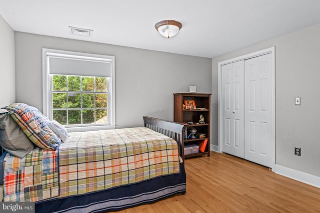 bedroom with light wood-type flooring and a closet