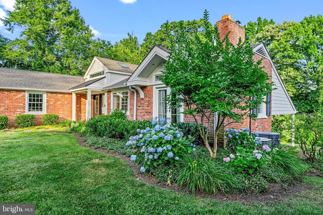 view of front of house featuring cooling unit and a front yard