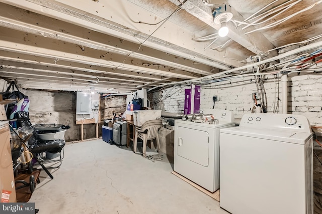 basement with electric panel and washer and dryer