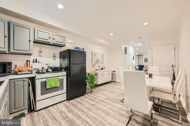 kitchen featuring black appliances, gray cabinetry, and light hardwood / wood-style flooring