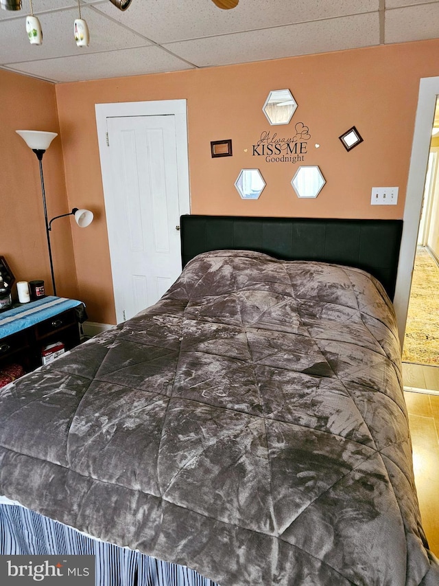 bedroom featuring a drop ceiling and a closet